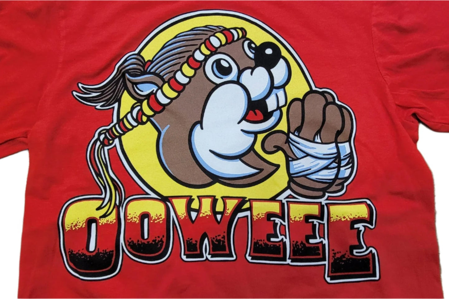 A beaver in a beaded headband and bandaged paw strikes a Muay Thai pose on red above bold yellow and black OOWEEE text on the Retro Grappler Oowee Muay Thai Beaver Tee.