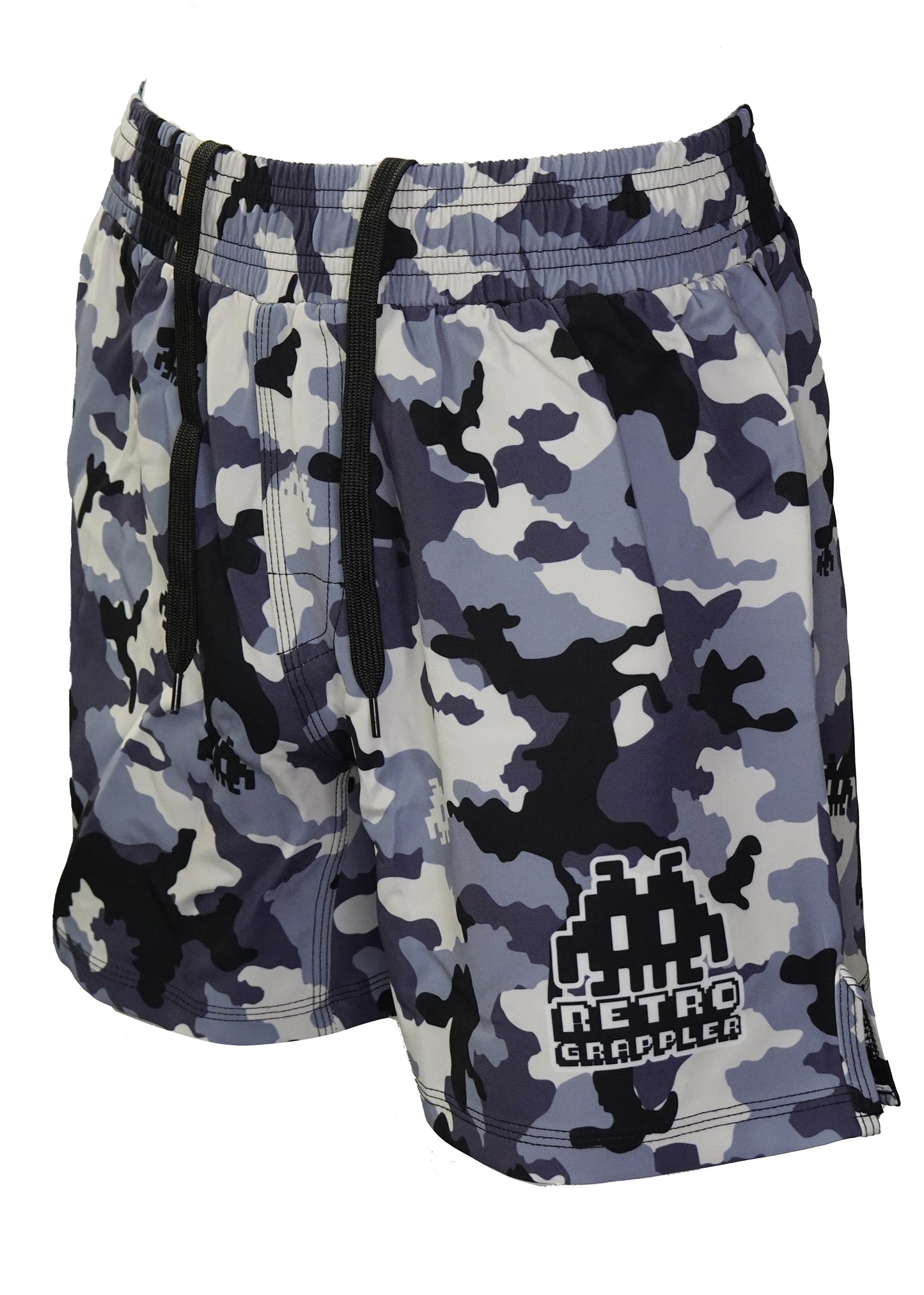Retro Grappler’s Dark Woodland Camo Grappling Shorts feature blue, black, gray, and white camo, a black drawstring, no Velcro, and an 8-bit space invader logo on the left leg—designed for lightweight comfort during BJJ training.