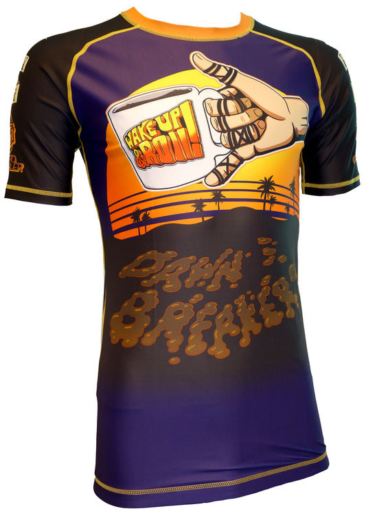 The Retro Grappler Dawn Breakers Rash Guard features short sleeves, a sunset beach scene with palm trees, a coffee mug reading Wake Up Bro!!!, and bold “Dawn Breakers” and “Gracie La Mesa DawnBreakers” on the front.