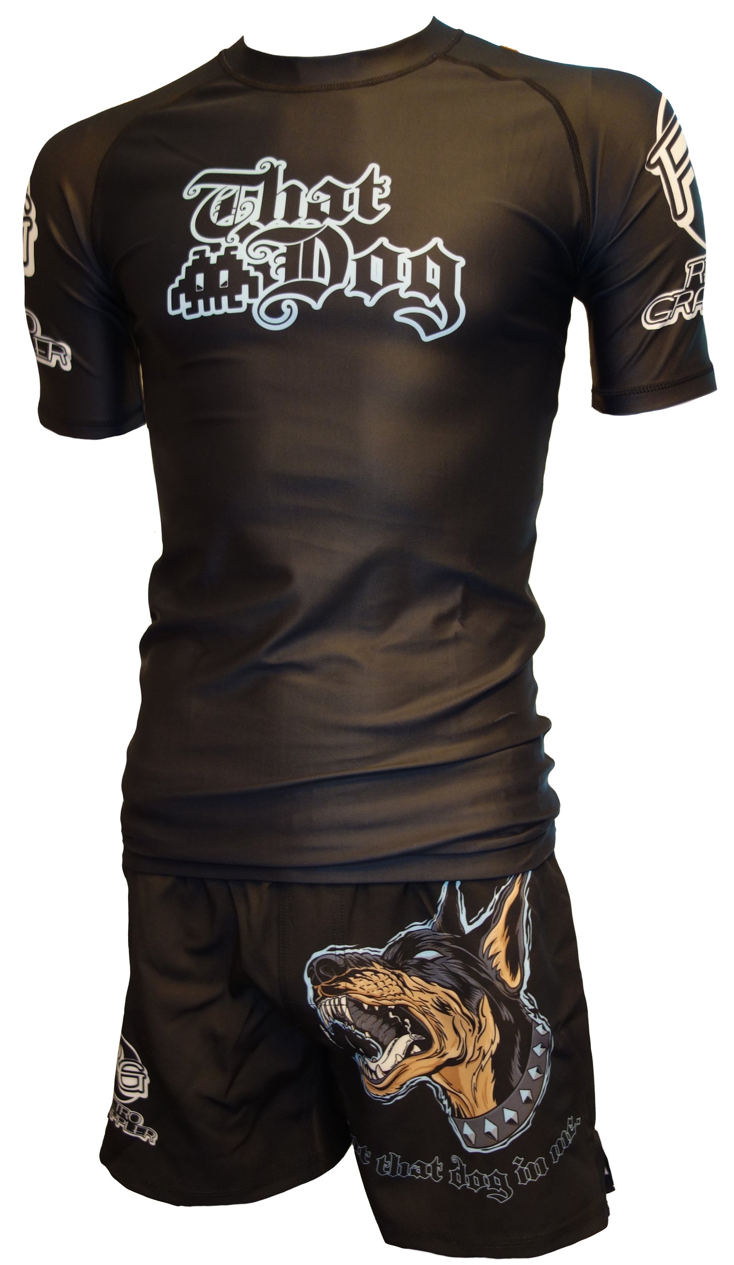 The Retro Grappler That Dog Jiu Jitsu Rash Guard set includes a black shirt with That Dog, bold white sleeve text, and shorts featuring a large snarling dog graphic—perfect for grappling and jiu jitsu enthusiasts.