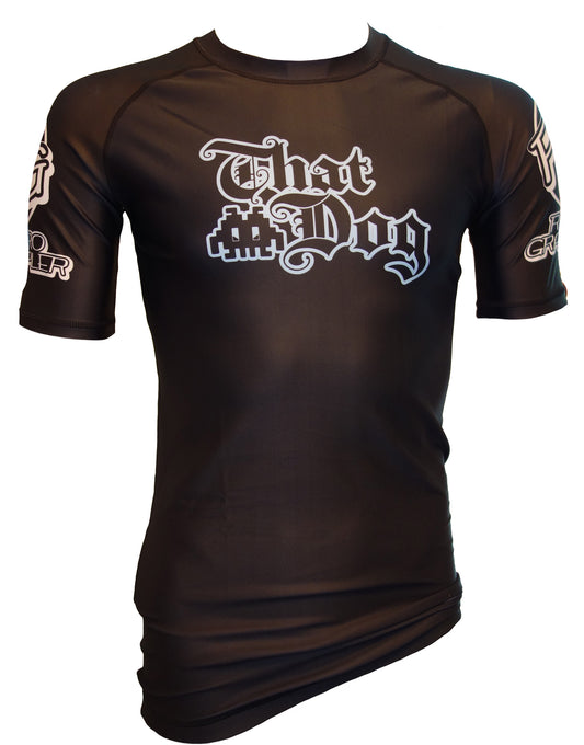 The Retro Grappler That Dog Jiu Jitsu Rash Guard is a black short-sleeve athletic shirt with stylish white text and graphics on the front and sleeves. Ideal for training, its shown on a torso mannequin against a white background.