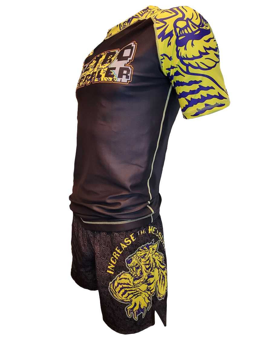 The Retro Grappler Tiger Pressure BJJ Rash Guard is a black and yellow athletic set with bold graphics, a fierce lion illustration, and INCREASE THE HE on the shorts—perfect for grappling or Brazilian Jiu-Jitsu.