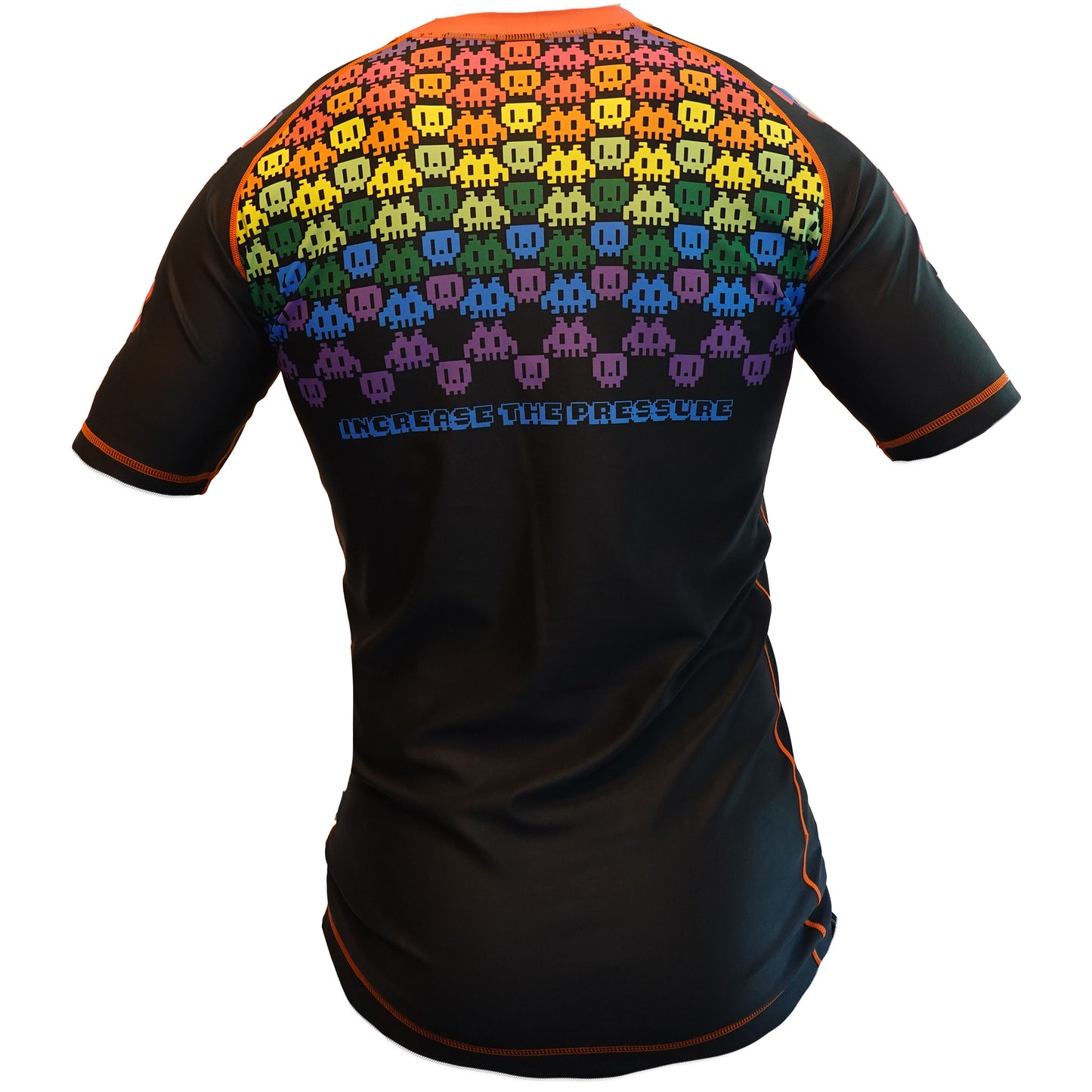 The Retro Grappler 8-Bit Rainbow Rash Guard is a black short-sleeve top with orange stitching, pixelated rainbow alien figures across the upper back, and INCREASE THE PRESSURE below—ideal for no-gi grappling or BJJ.