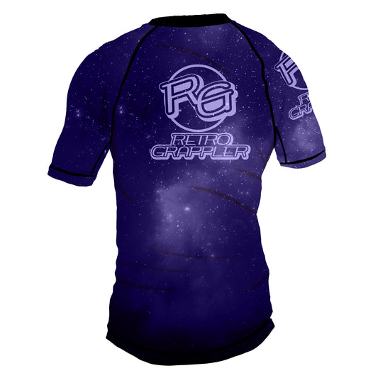 The Youth - Galaxy Increase the Pressure Rash Guard by Retro Grappler features a galaxy-inspired purple and navy design, four-way stretch fabric for comfort, and the RG Retro Grappler logo in white on the back and sleeve.