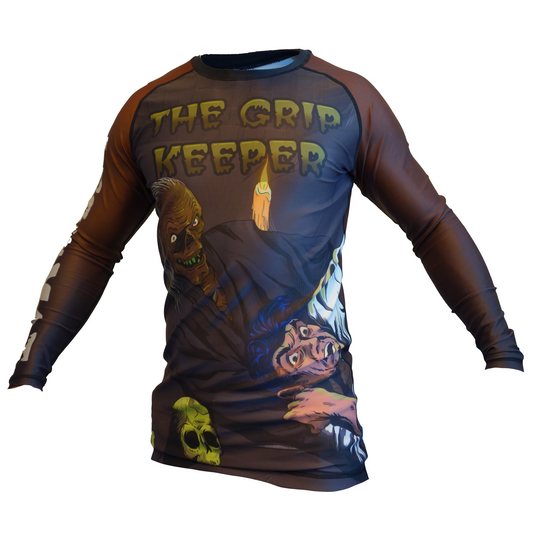 The Grip Keeper Horror BJJ Rash Guard by Retro Grappler features cartoon art of a mummy creature and scared victim, THE GRIP KEEPER text on the chest, and a green skull—perfect for unique MMA rash guard fans.
