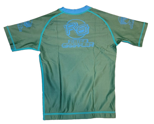 The Youth - Respectful Gator by Retro Grappler is a green short-sleeved athletic rash guard with blue trim, made from a polyester-spandex blend, featuring RG logos and Retro Grappler text on the back and sleeves.