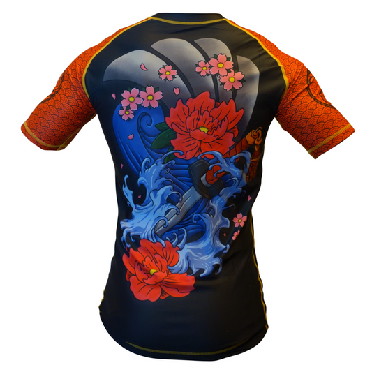The Retro Grappler Youth - Savage Oni Mask Rashguard features short sleeves, a vibrant back with red flowers, blue waves, pink petals, Yakuza-inspired oni mask art, orange patterned sleeves, and yellow trim.